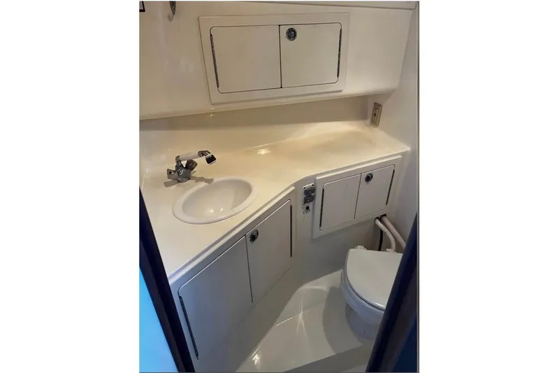 Slide: The Image of 2005 Carolina Classic 28 boat bathroom with sink, cabinets, and toilet. - 9