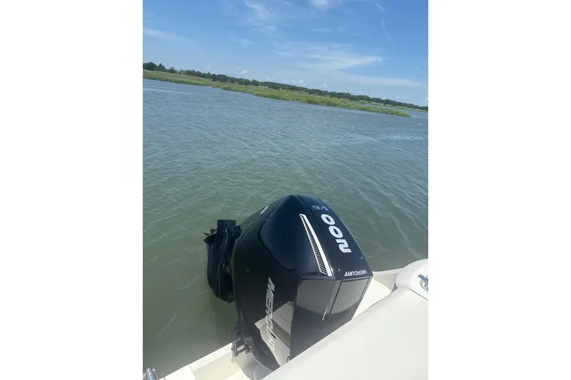 Slide: The Image of 2024 Cobia 220 Dual Console with Mercury 200 engine on calm water. - 10