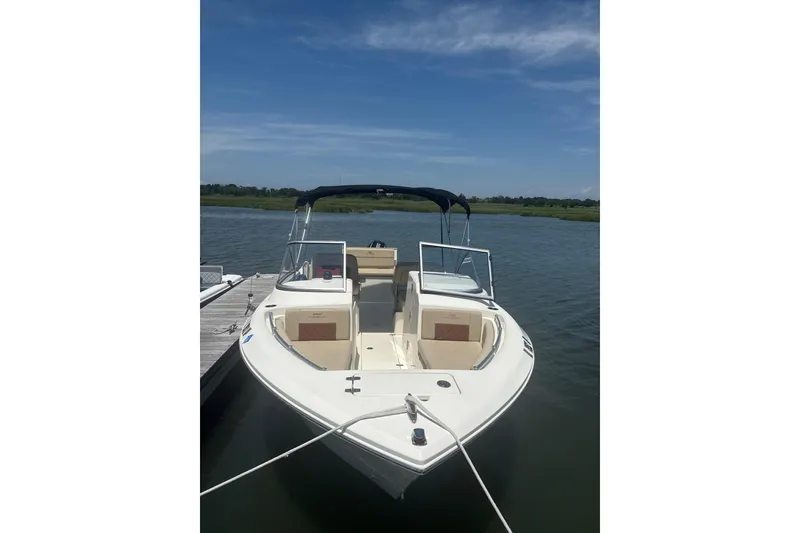 Slide: The Image of 2024 Cobia 220 Dual Console boat docked on a sunny day. - 3