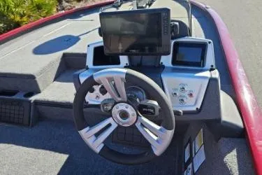 Slide: The Image of 2025 Tracker Savage 215 boat on trailer, parked outdoors, under clear blue sky. - 3