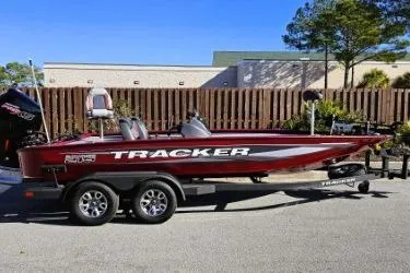 Slide: The Image of 2025 Tracker Savage 215 boat with advanced fishing equipment, parked outdoors. - 7