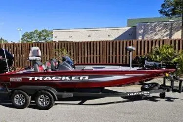 Slide: The Image of 2025 Tracker Savage 215 boat on trailer, red and black design, parked outdoors. - 9