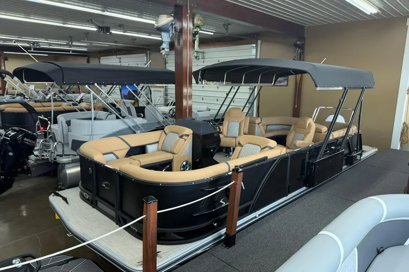 The Image of 2026 Crest Caribbean 230 SLC pontoon boat with beige seating in showroom. - 0