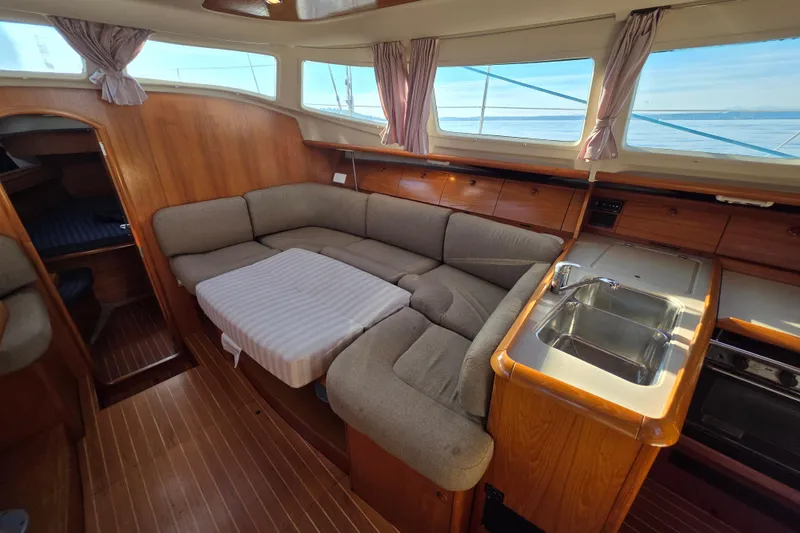 Slide: The Image of Interior of 1999 Jeanneau Sun Odyssey 40 DS sailboat with cozy seating and kitchenette. - 12