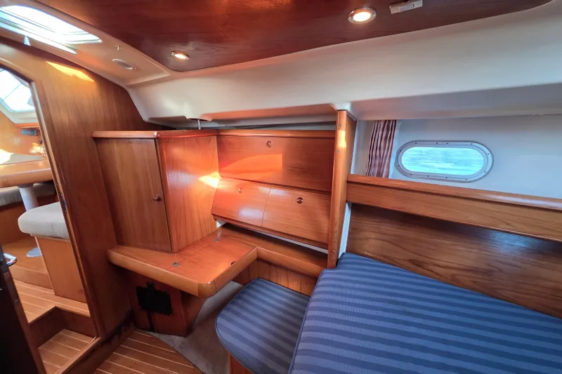 Slide: The Image of Interior of 1999 Jeanneau Sun Odyssey 40 DS yacht with wooden cabinetry and striped seating. - 15