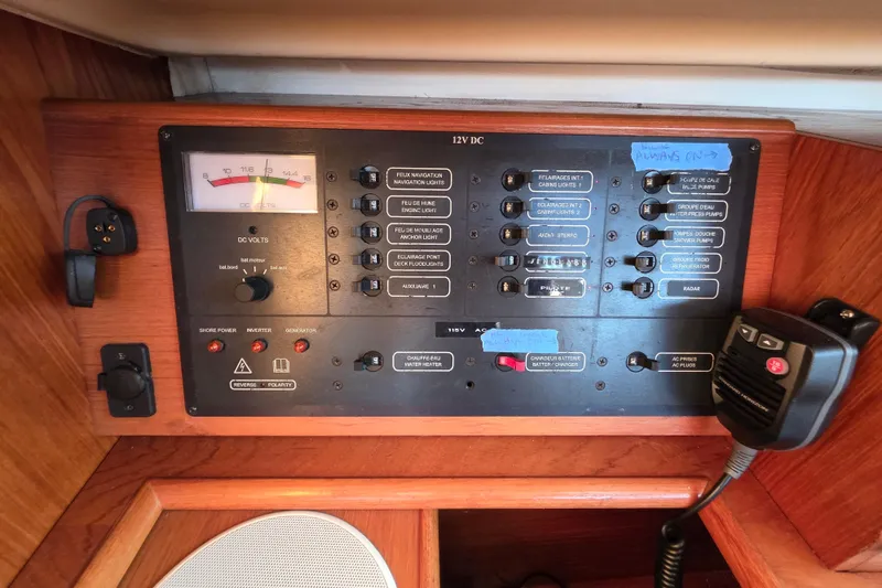 Slide: The Image of Control panel of a 1999 Jeanneau Sun Odyssey 40 DS sailboat, featuring various switches and a voltmeter. - 20