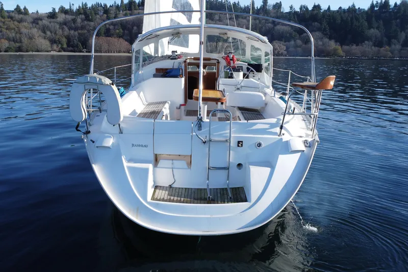 Slide: The Image of 1999 Jeanneau Sun Odyssey 40 DS sailboat on calm water, surrounded by forested shoreline. - 3