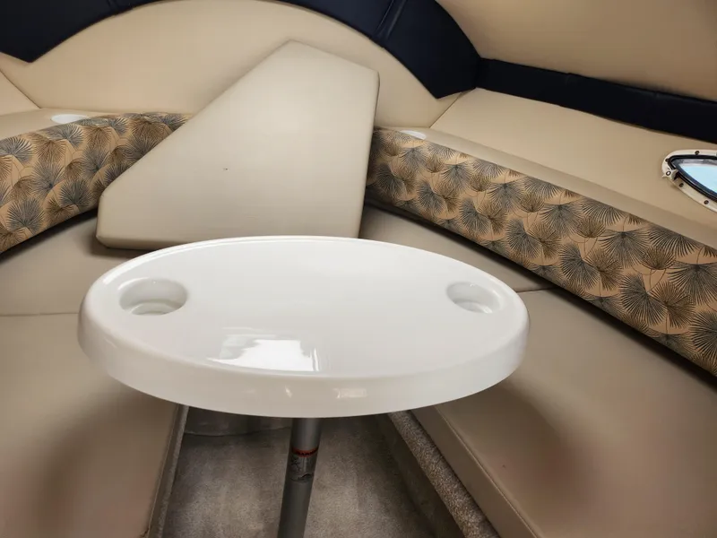 Slide: The Image of Interior seating area of 2008 Glastron GT 249 boat with table and cushioned seats. - 21