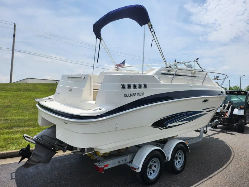 Slide: The Image of 2008 Glastron GT 249 boat on a trailer, rear view with blue canopy. - 3