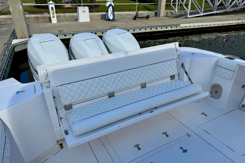 Slide: The Image of 2022 Intrepid 409 Valor boat with white quilted seating and triple outboard engines. - 12