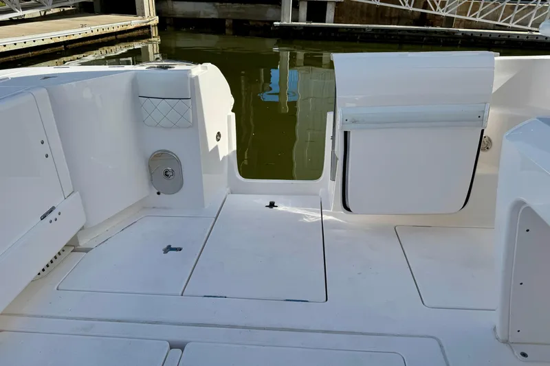 Slide: The Image of 2022 Intrepid 409 Valor boat deck with open hatch, docked by the water. - 15