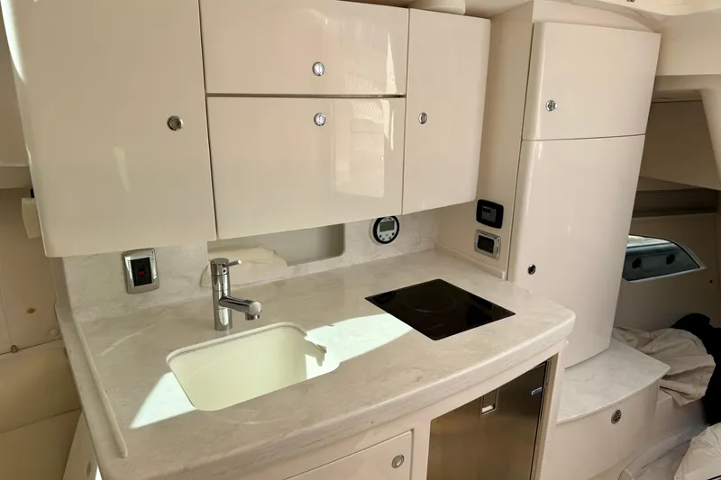 Slide: The Image of 2022 Intrepid 409 Valor yacht interior with modern kitchenette and sleek cabinetry. - 18