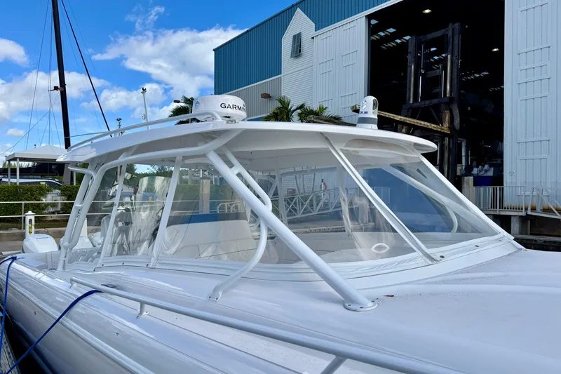 Slide: The Image of 2022 Intrepid 409 Valor boat docked near a marina with clear blue skies. - 2