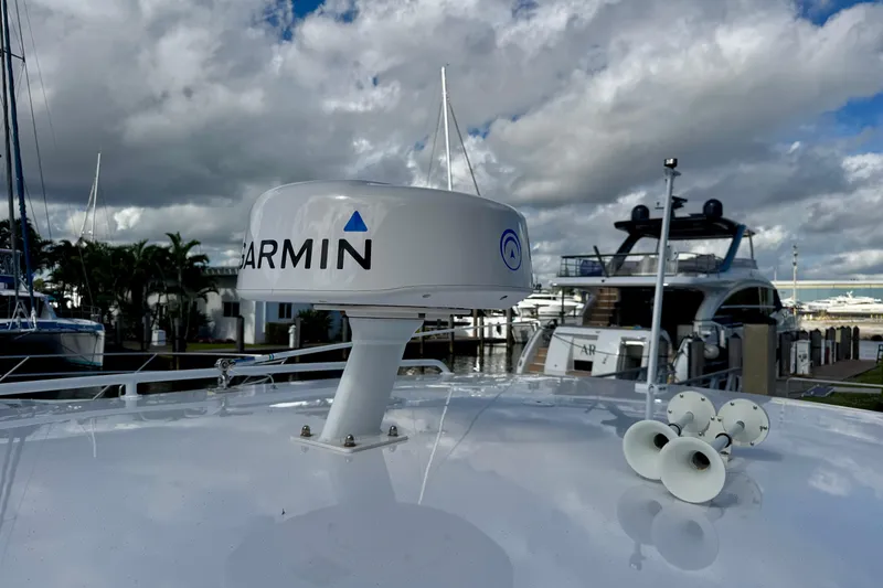 Slide: The Image of 2022 Intrepid 409 Valor boat with Garmin radar, docked under cloudy sky. - 21
