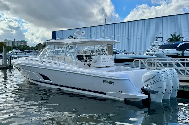 Slide: The Image of 2022 Intrepid 409 Valor boat docked with triple Mercury engines. - 25