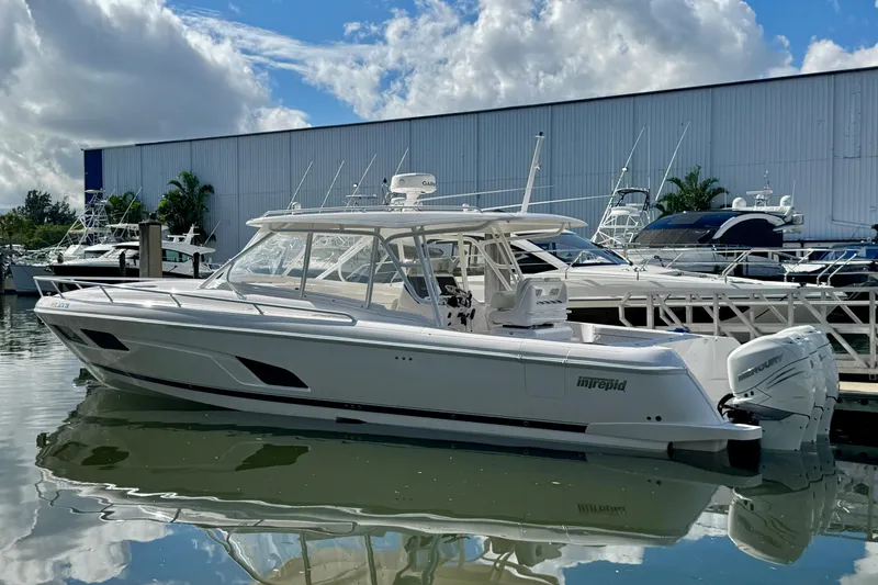 Slide: The Image of 2022 Intrepid 409 Valor boat docked at marina under blue sky. - 3