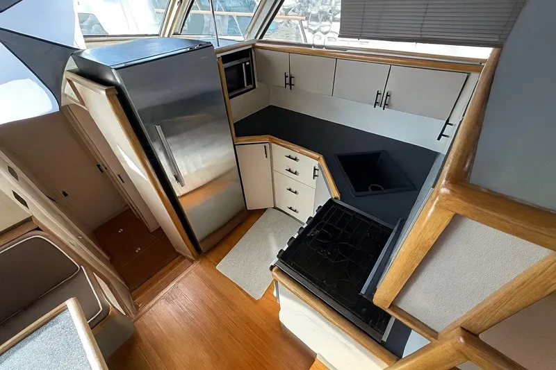 Slide: The Image of 1985 Symbol 58 Cockpit Motor Yacht kitchen with modern appliances and wood accents. - 12