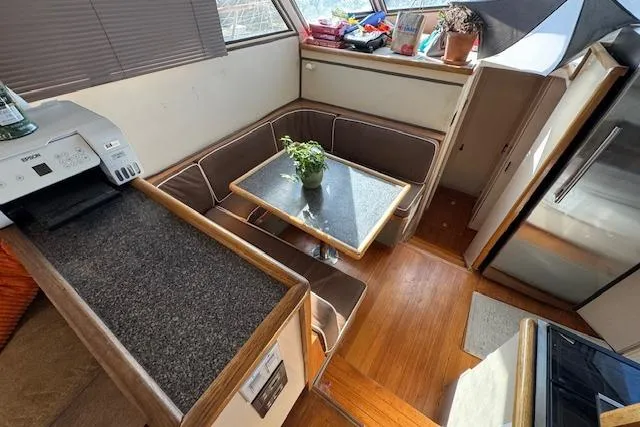 Slide: The Image of 1985 Symbol 58 Cockpit Motor Yacht interior with dining area, table, and potted plant. - 14