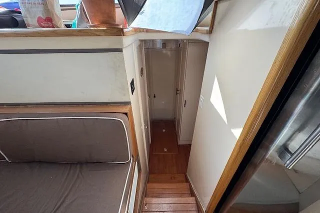 Slide: The Image of 1985 Symbol 58 Cockpit Motor Yacht interior with wooden stairs and seating area. - 16