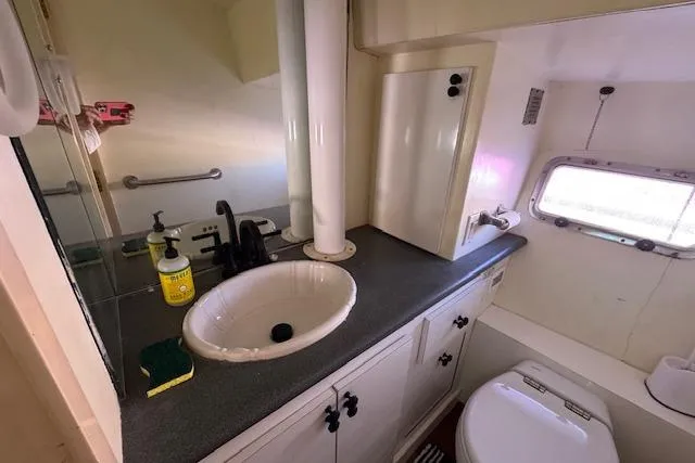 Slide: The Image of 1985 Symbol 58 Cockpit Motor Yacht bathroom with sink, mirror, and window. - 18