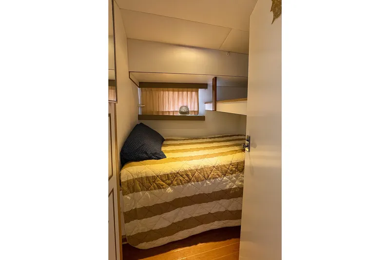 Slide: The Image of Cozy cabin interior of 1985 Symbol 58 Cockpit Motor Yacht with striped bedding. - 19