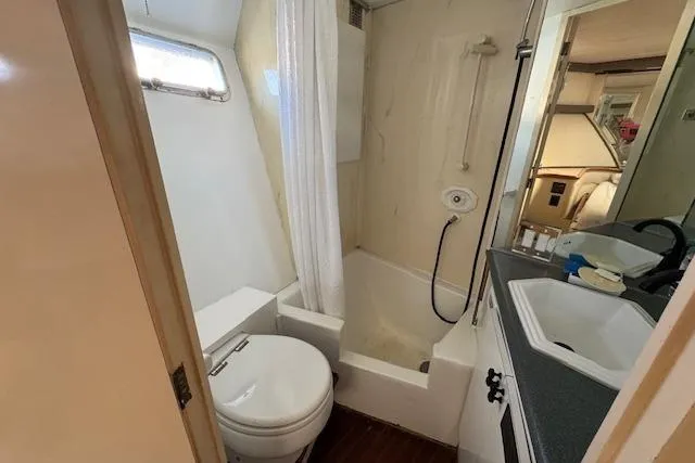 Slide: The Image of 1985 Symbol 58 Cockpit Motor Yacht bathroom with shower, sink, and toilet. - 21