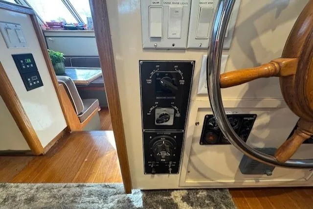 Slide: The Image of 1985 Symbol 58 Cockpit Motor Yacht helm with wooden steering wheel and control panel. - 37