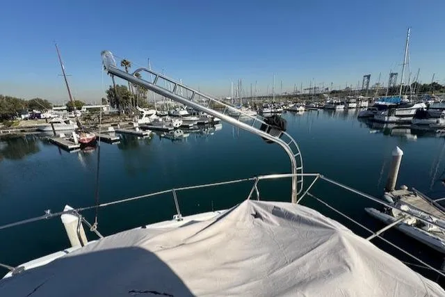 Slide: The Image of 1985 Symbol 58 Cockpit Motor Yacht docked in a serene marina setting. - 48