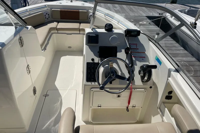 Slide: The Image of 2024 Cobia 220 Dual Console boat interior with steering wheel and seating. - 4