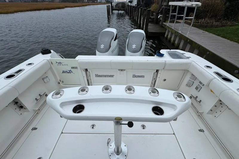 Slide: The Image of 2016 Boston Whaler 315 Conquest boat with dual Suzuki outboard engines, docked by a wooden pier. - 13