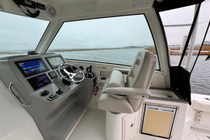 Slide: The Image of 2016 Boston Whaler 315 Conquest helm with modern navigation displays and comfortable seating. - 23