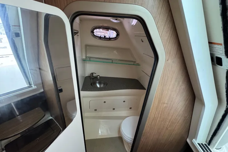 Slide: The Image of 2016 Boston Whaler 315 Conquest boat bathroom with sink and porthole window. - 25
