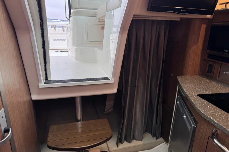 Slide: The Image of Interior view of a 2016 Boston Whaler 315 Conquest boat cabin with seating and kitchenette. - 26