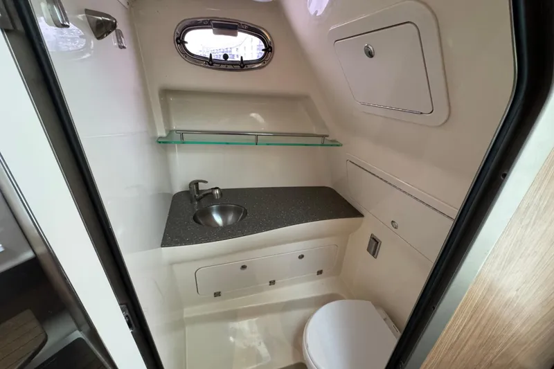 Slide: The Image of 2016 Boston Whaler 315 Conquest bathroom with sink, toilet, and storage. - 31