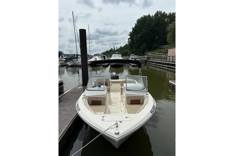The Image of 2024 Cobia 220 Dual Console boat docked at marina, overcast sky. - 1