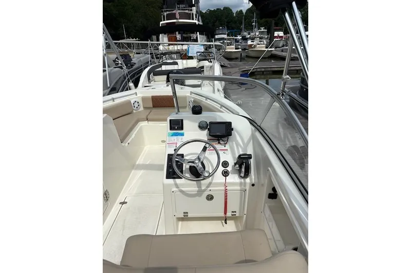 Slide: The Image of 2024 Cobia 220 Dual Console boat interior with steering wheel and dashboard controls. - 6