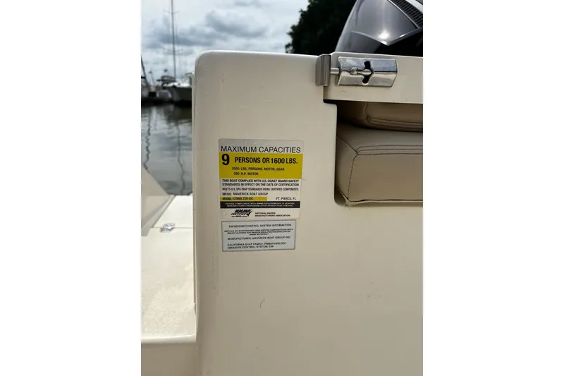 Slide: The Image of 2024 Cobia 220 Dual Console boat capacity label, maximum 9 persons or 1600 lbs. - 9