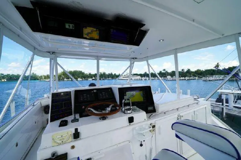 Slide: The Image of 1981 Bertram Convertible boat cockpit with navigation equipment and waterfront view. - 13