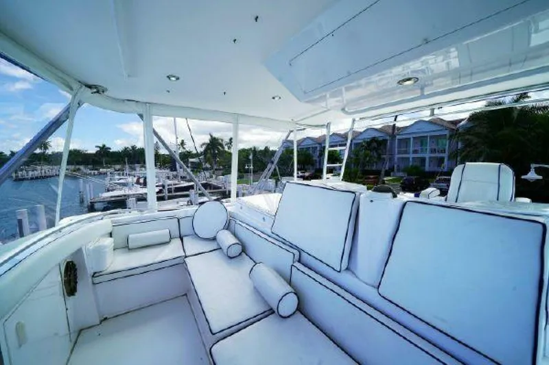 Slide: The Image of 1981 Bertram Convertible yacht interior with white cushioned seating and marina view. - 20