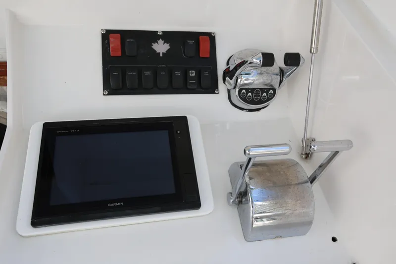 Slide: The Image of 1981 Bertram Convertible boat controls with Garmin GPS and throttle levers. - 43