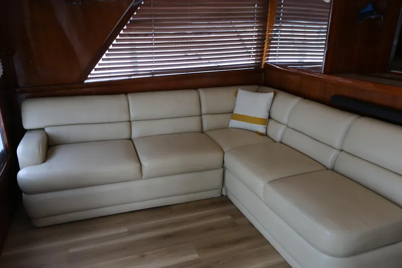 Slide: The Image of Cream leather sofa in 1981 Bertram Convertible yacht interior, with wooden blinds and flooring. - 44