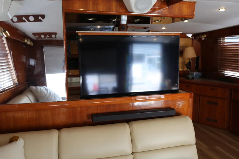 Slide: The Image of Interior of a 1981 Bertram Convertible yacht with a mounted TV and wooden decor. - 47