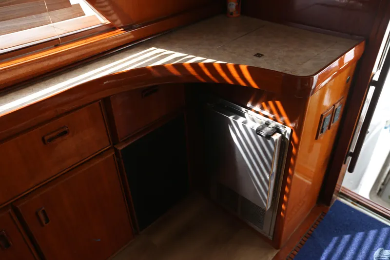 Slide: The Image of 1981 Bertram Convertible interior with wooden cabinetry and compact refrigerator. - 48
