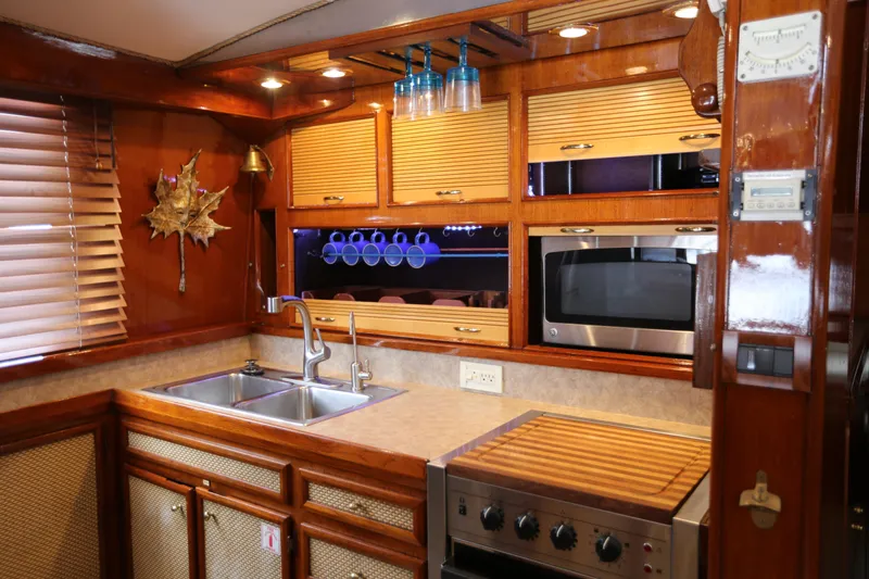 Slide: The Image of 1981 Bertram Convertible yacht kitchen with wooden cabinets, stainless steel sink, and modern appliances. - 50