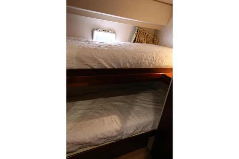 Slide: The Image of Bunk beds in 1981 Bertram Convertible yacht cabin with window and pillows. - 52