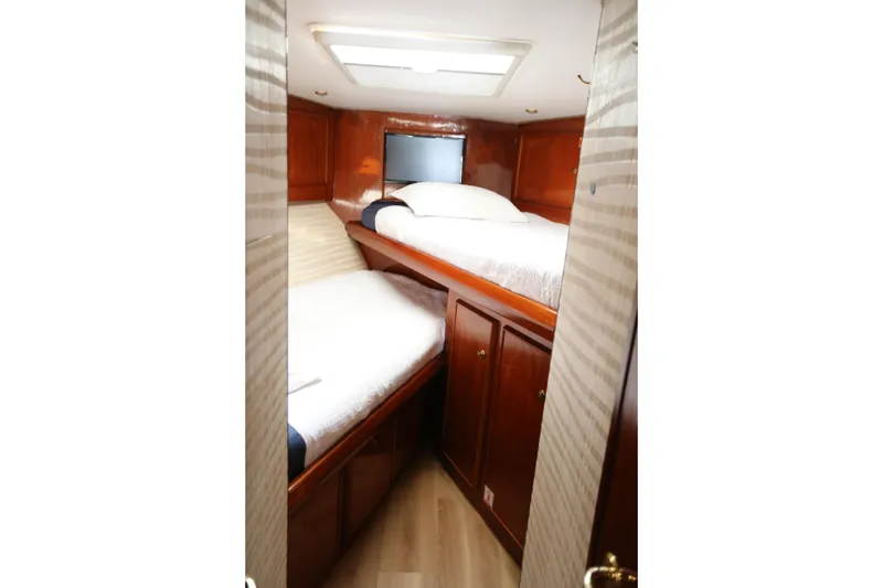 Slide: The Image of 1981 Bertram Convertible cabin interior with wooden finish and twin beds. - 55