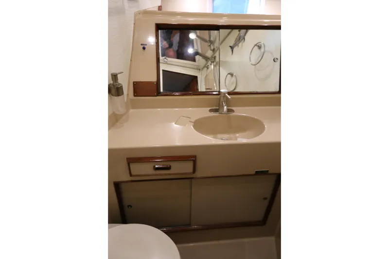 Slide: The Image of 1981 Bertram Convertible yacht bathroom with sink, mirror, and storage cabinet. - 56