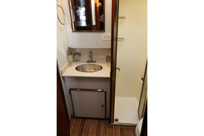 Slide: The Image of 1981 Bertram Convertible yacht bathroom with sink, mirror, and shower. - 58