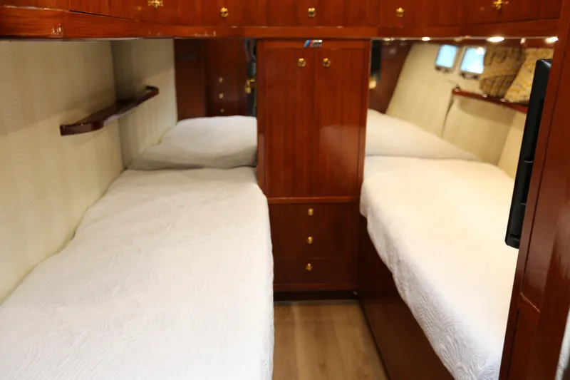 Slide: The Image of Interior of 1981 Bertram Convertible yacht with twin beds and wooden cabinetry. - 61