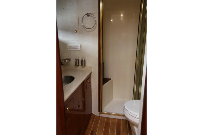 Slide: The Image of 1981 Bertram Convertible yacht bathroom with shower, sink, and wooden flooring. - 63